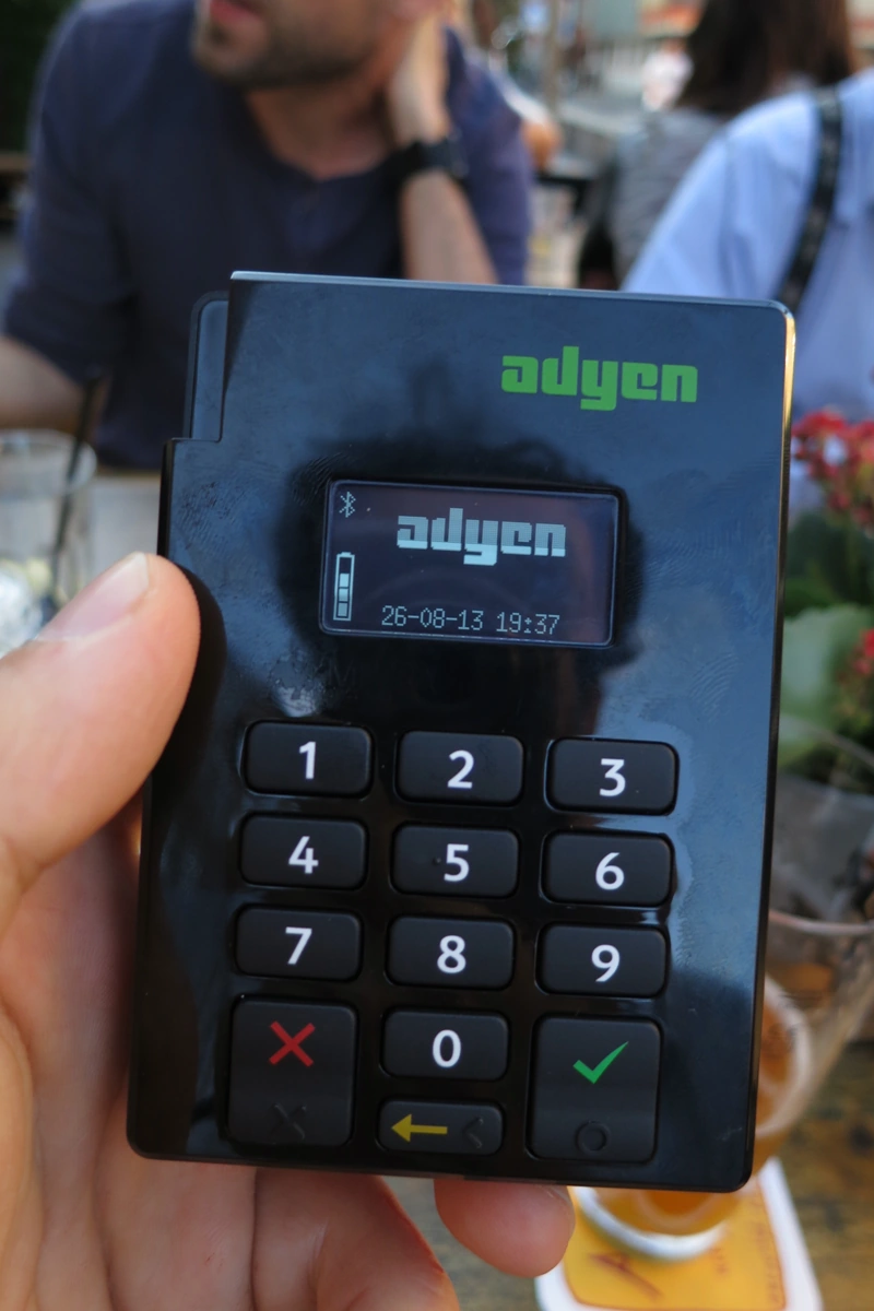 Card payment terminal illustrating a currency choice at checkout