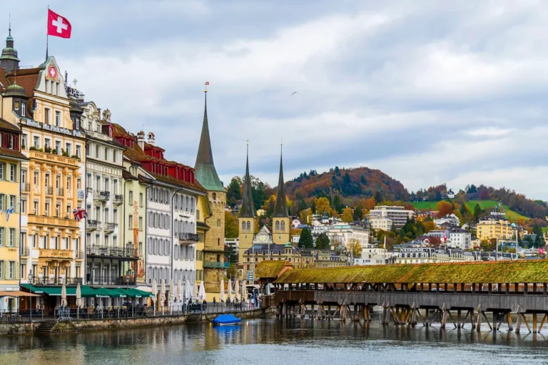 Colorful Rathausquai facades and Chapel Bridge under overcast sky — things to do in Lucerne when it rains.