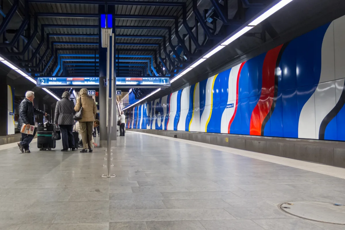 Passengers with suitcases on platforms 1 and 2 at Zürich Flughafen station