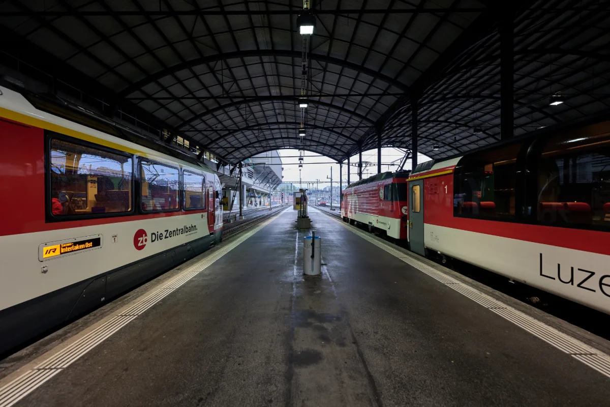 Red trains under the arched train hall at Luzern station on arrival from Zurich Airport