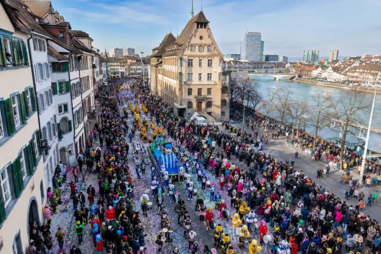 AI-generated elevated daytime view of a colorful Basel Carnival procession beside the Rhine.