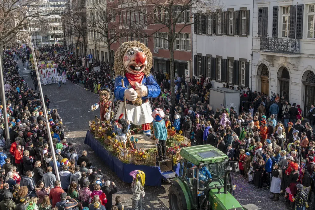 AI-generated daytime illustration of a large carnival float moving through a crowded Basel street.