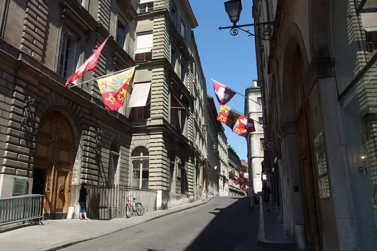 Rue de l’Hôtel-de-Ville with historic buildings and Geneva flags
