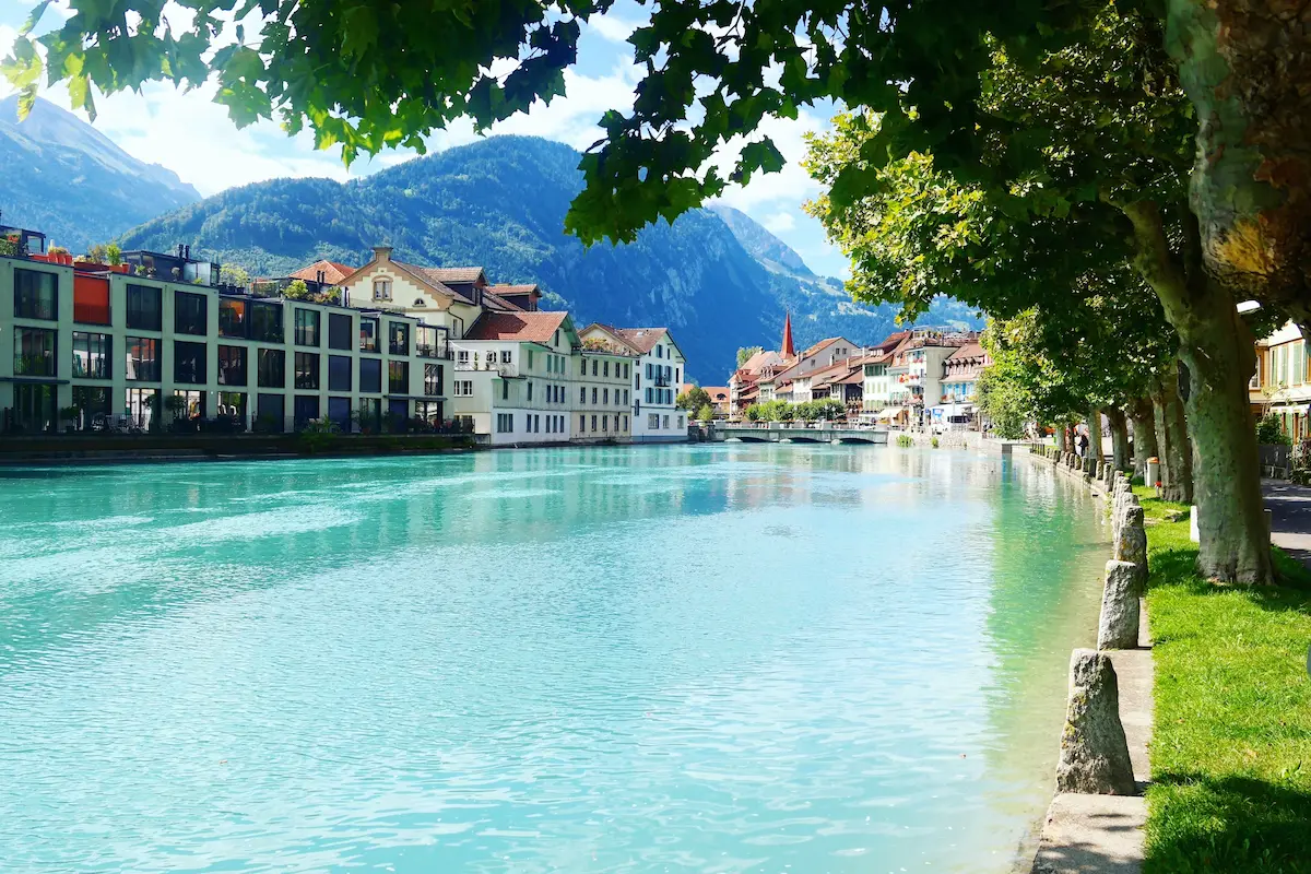 Interlaken riverside with colorful buildings and Alpine mountains