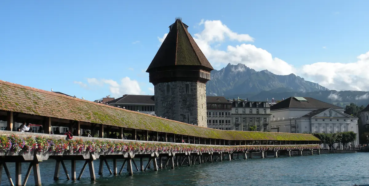 Chapel Bridge and Water Tower in Lucerne with Mount Pilatus behind them