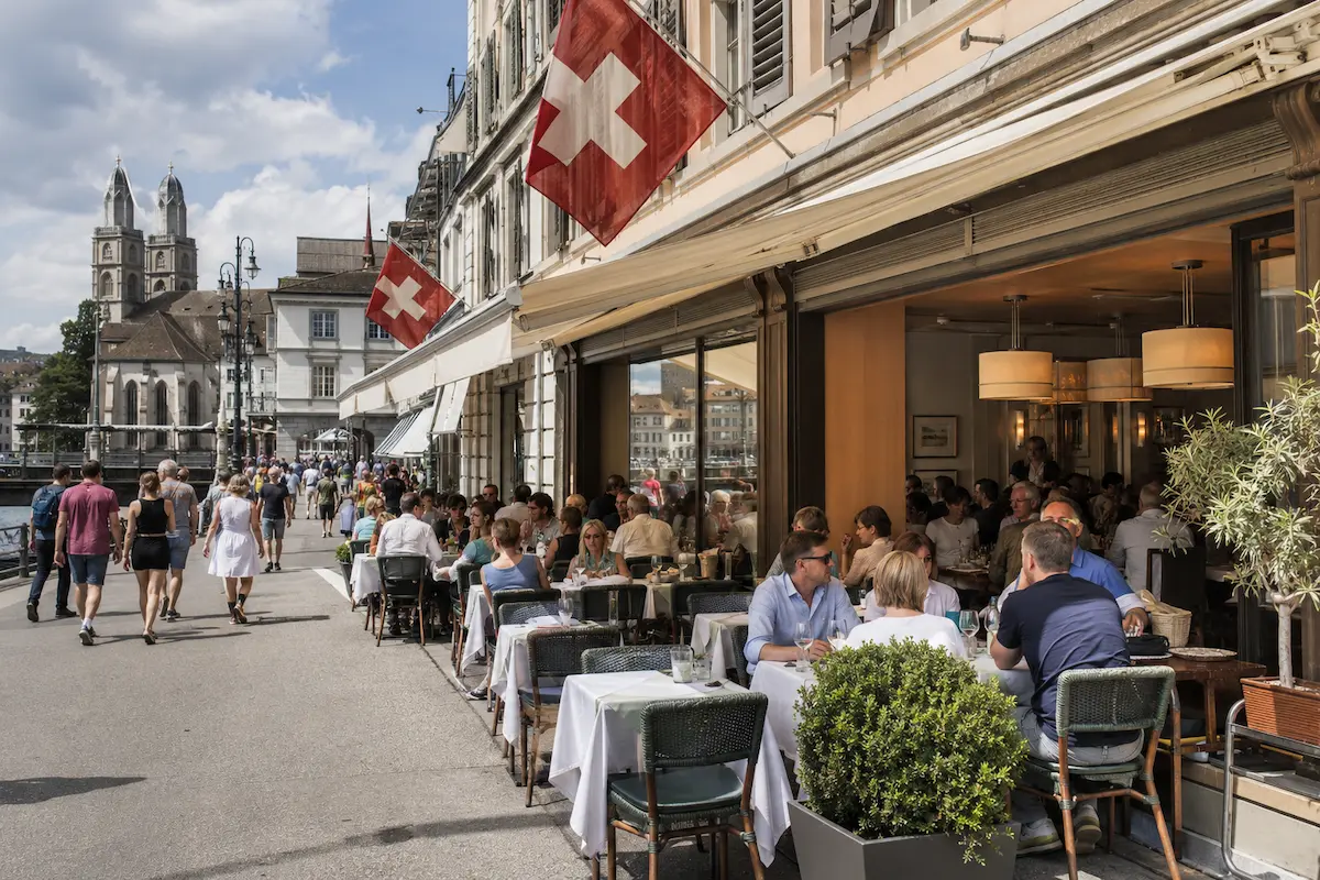 Restaurant terrace with diners in a Swiss city on Sunday
