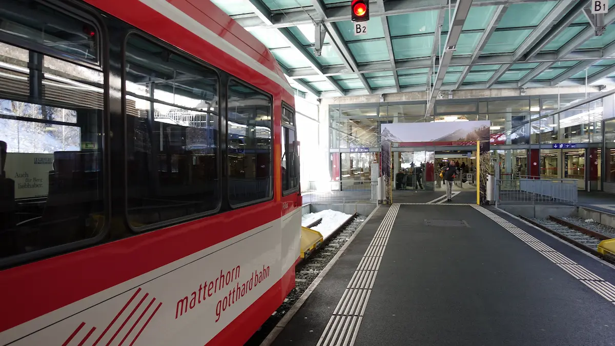 Matterhorn Gotthard Bahn train at Täsch station beside the covered passenger transfer area