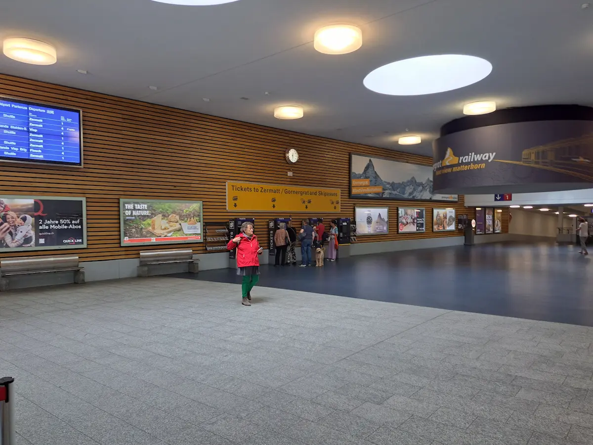 Ticket hall inside Täsch railway station with departure information for Zermatt