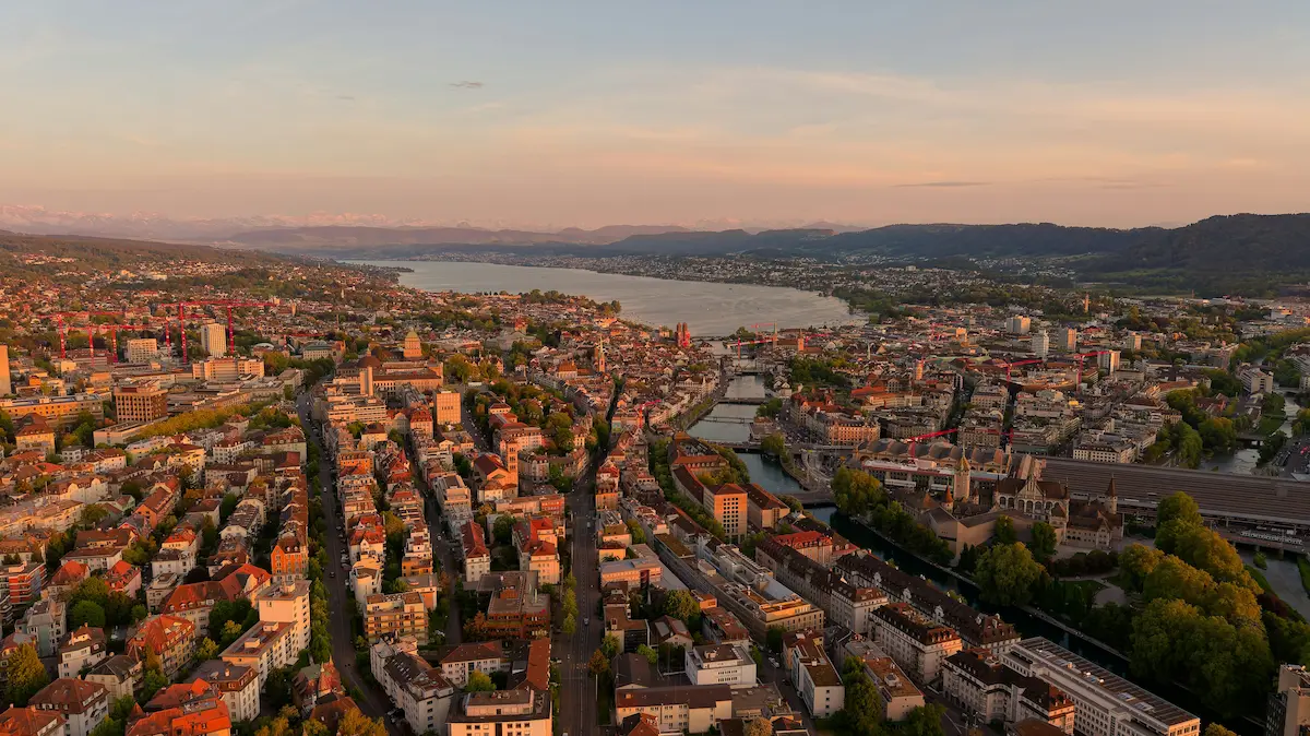 Aerial view of Zurich and Lake Zurich at golden hour with mountains in the distance