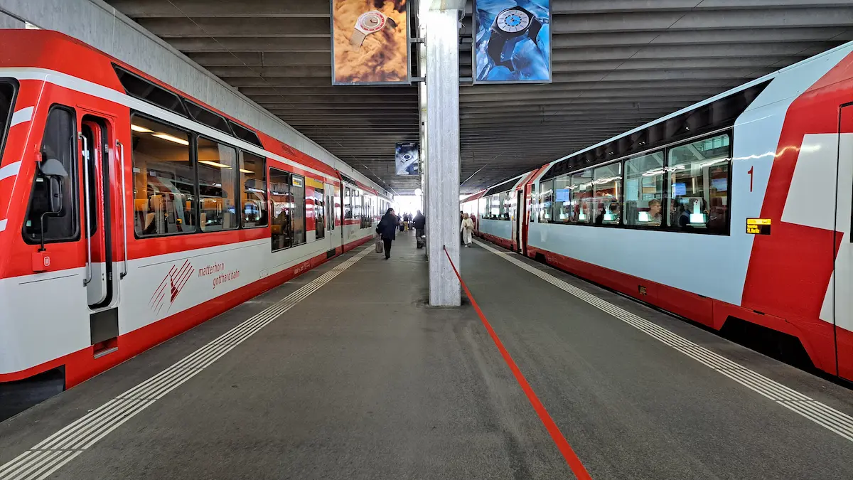 Two Matterhorn Gotthard Bahn trains beside the central platform at Zermatt railway station