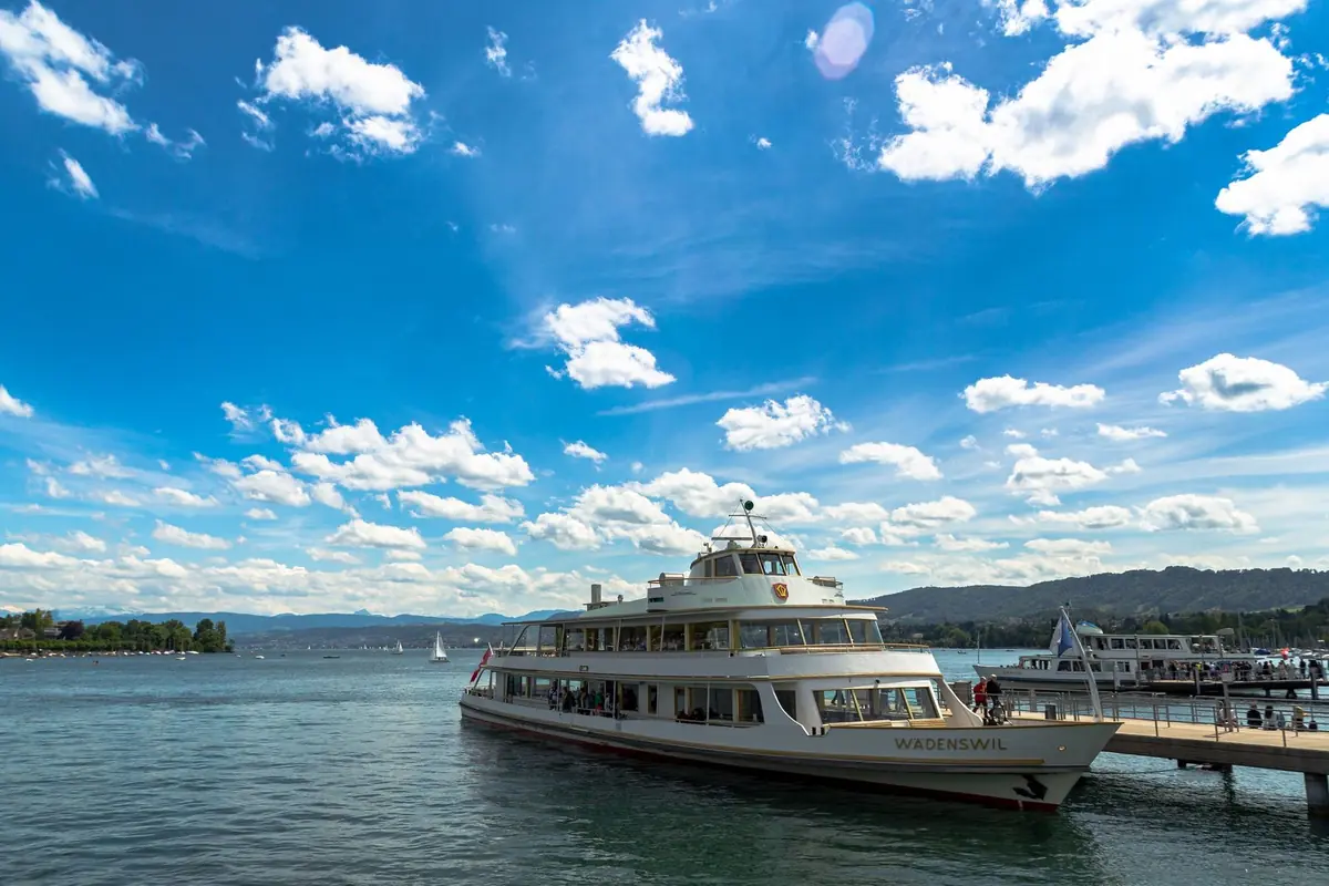Passenger ferry docked on Lake Zurich under a bright blue sky