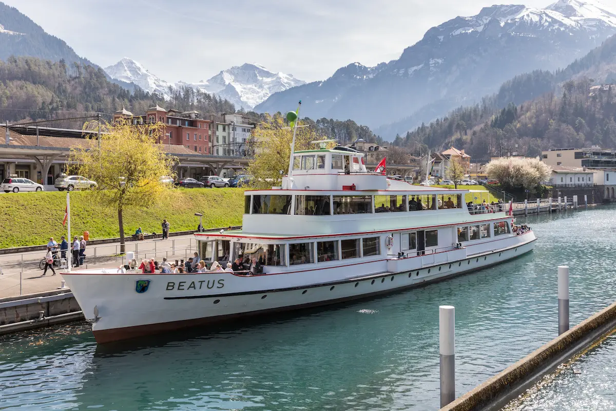 MS Beatus boat at Interlaken West with the station area and mountains behind